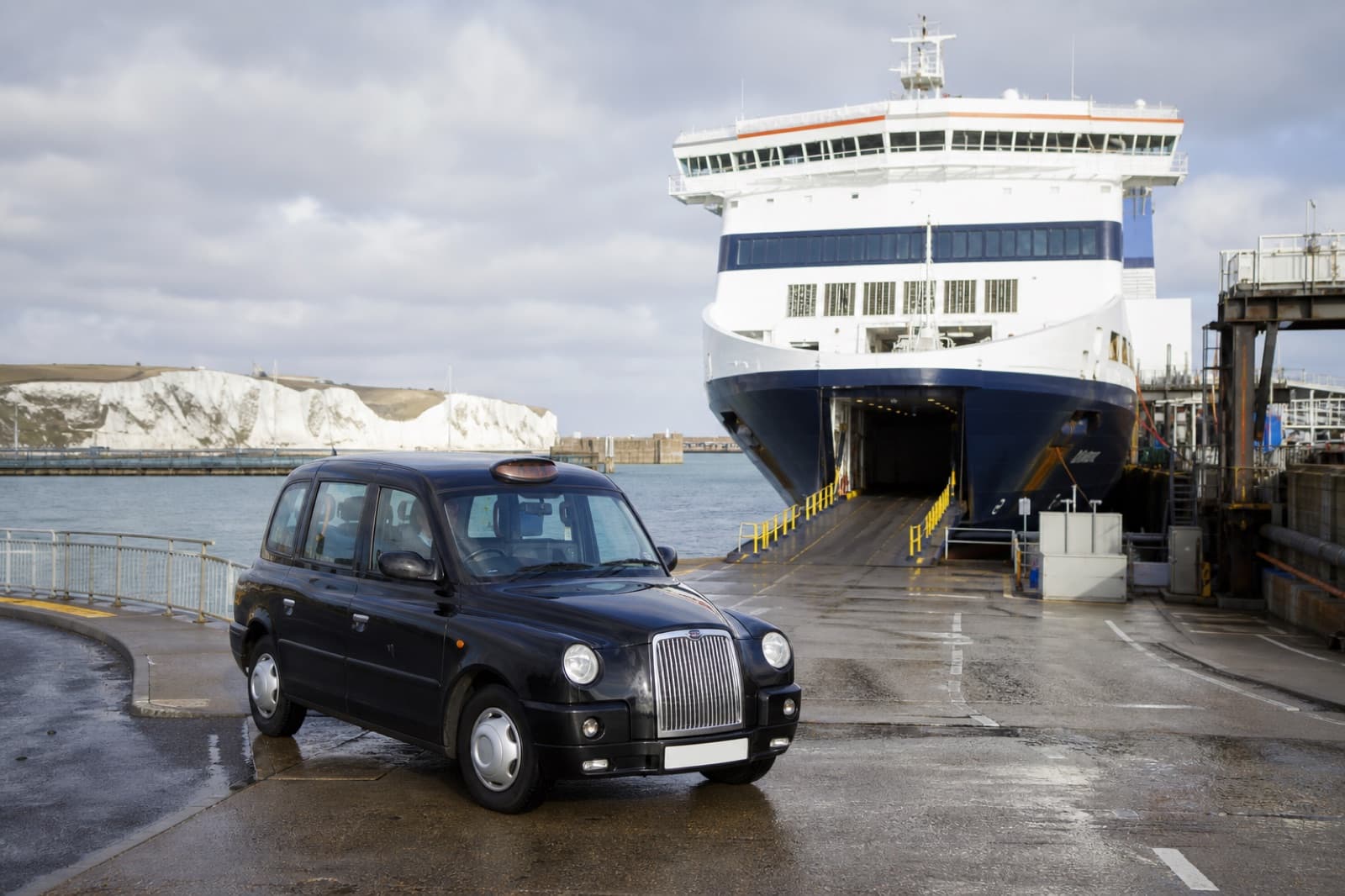 Taxi at Dover ferry port with ferry in background